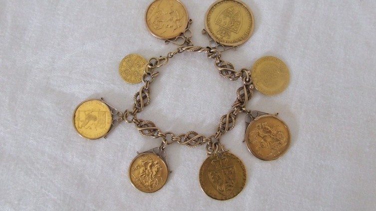 A bracelet of eight gold coins and medallions (£2000)